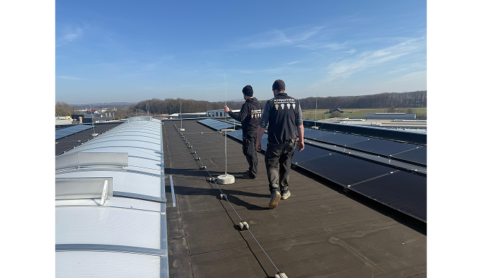Zwei Techniker auf einem Flachdach mit Solarmodulen Zwei Techniker auf einem Flachdach mit Solarmodulen