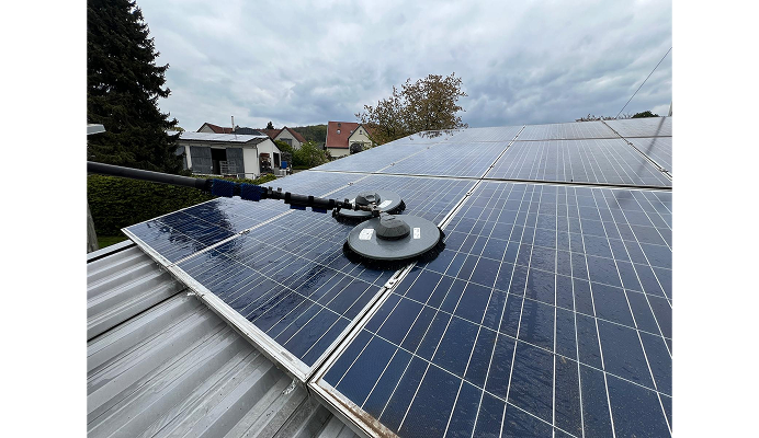 Hausdach mit Solarpaneelen, die gesäubert werden Hausdach mit Solarpaneelen, die gesäubert werden