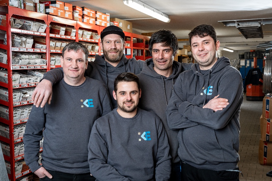 Fünf Mitarbeiter in einheitlichen Sweatshirts mit Firmenlogo Fünf Mitarbeiter in einheitlichen Sweatshirts mit Firmenlogo